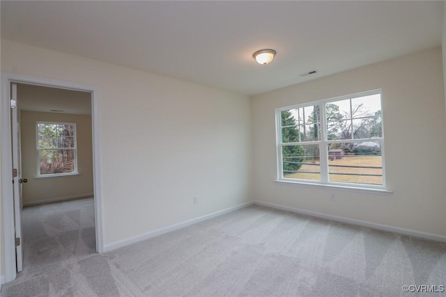 carpeted spare room featuring a wealth of natural light