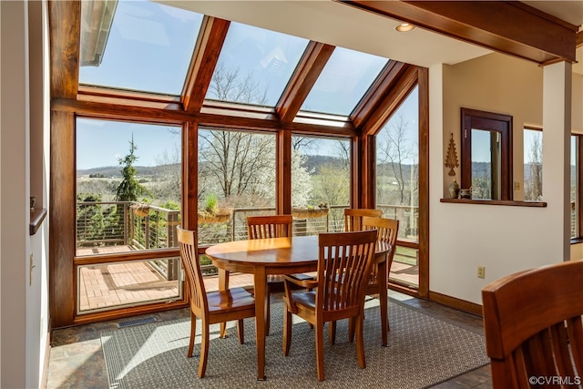 sunroom / solarium featuring a skylight and beamed ceiling