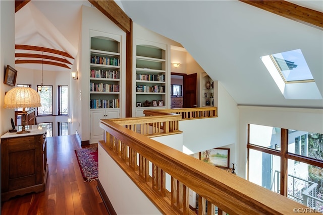 hall featuring dark hardwood / wood-style floors, lofted ceiling with skylight, built in shelves, and a notable chandelier