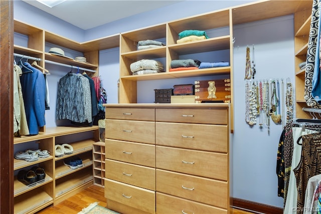 walk in closet with light hardwood / wood-style flooring