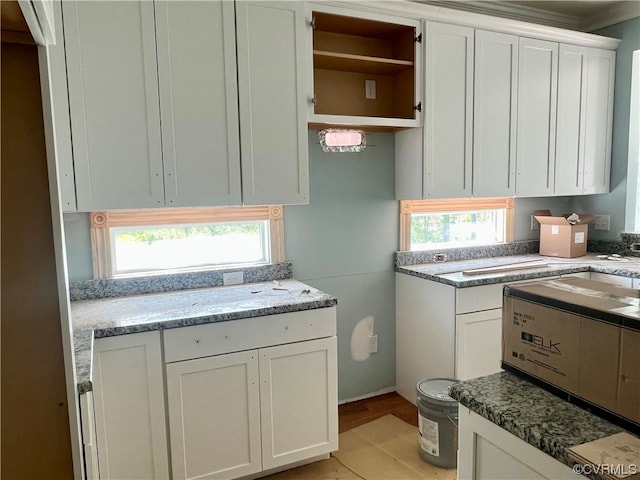 kitchen featuring white cabinetry, a wealth of natural light, and light stone countertops