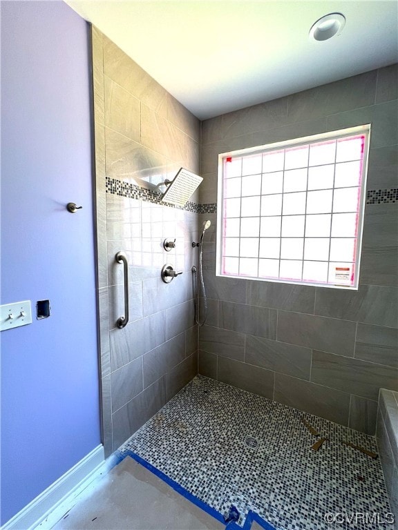 bathroom featuring a tile shower and baseboards