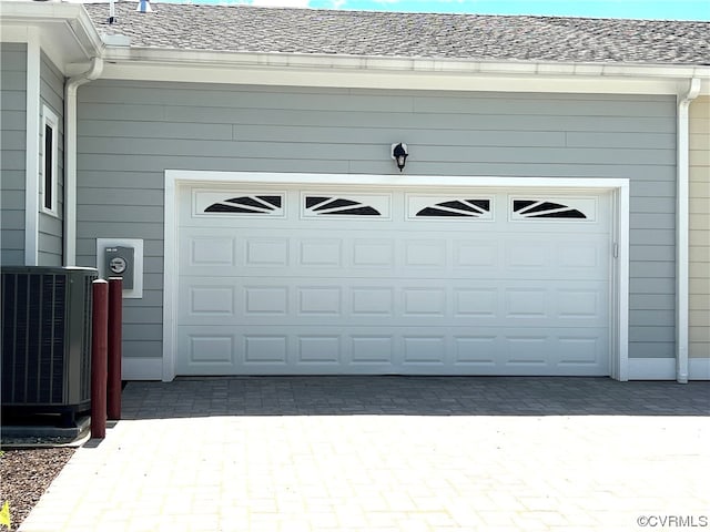 garage featuring decorative driveway and cooling unit