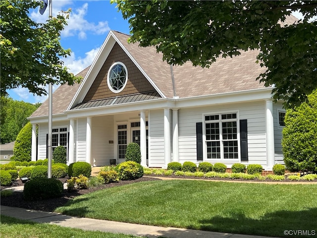 view of front of house featuring a standing seam roof, a front lawn, and metal roof