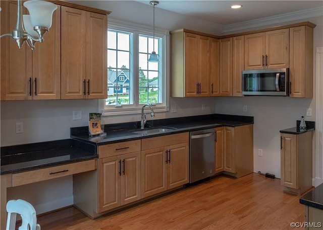 kitchen featuring pendant lighting, recessed lighting, appliances with stainless steel finishes, light wood-style floors, and a sink