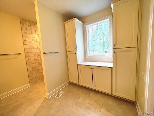 full bathroom with tile patterned flooring, baseboards, visible vents, and a tile shower