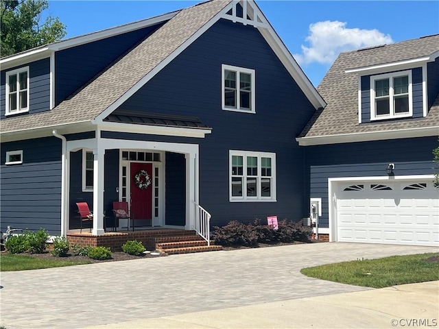 view of front of house with a porch, metal roof, driveway, and a shingled roof