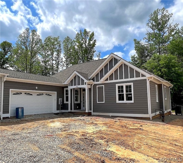 view of front of home with a garage, driveway, and a shingled roof