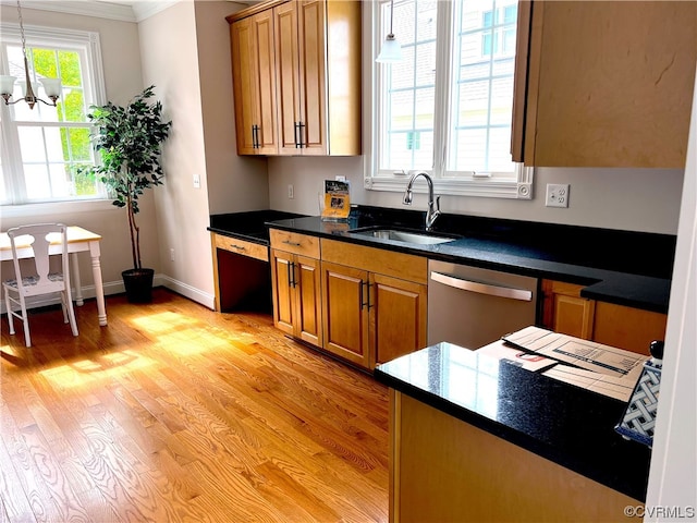 kitchen featuring a notable chandelier, a sink, stainless steel dishwasher, dark countertops, and light wood finished floors