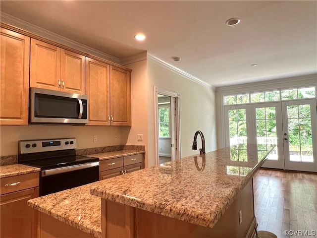 kitchen with ornamental molding, light stone counters, wood finished floors, recessed lighting, and stainless steel appliances