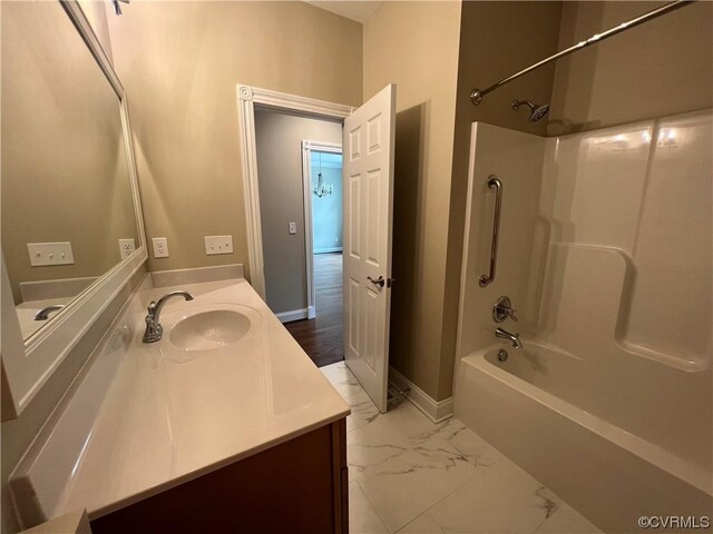 bathroom with baseboards, marble finish floor, shower / washtub combination, and vanity