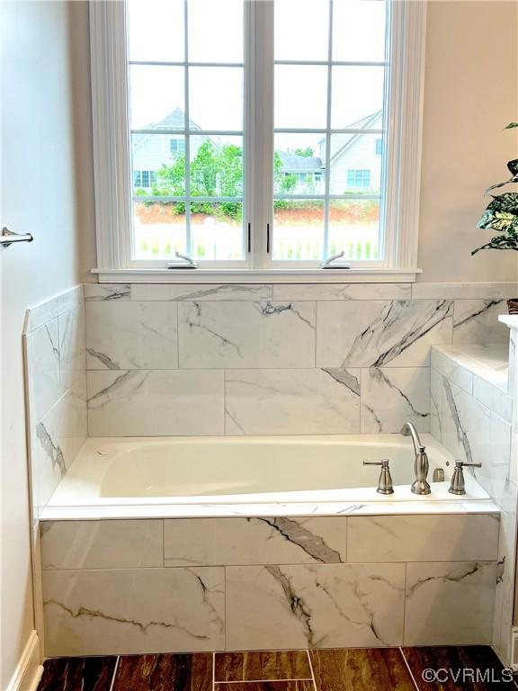 full bathroom featuring a garden tub and plenty of natural light