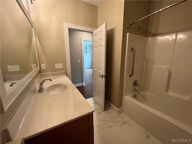 full bath featuring vanity, bathtub / shower combination, marble finish floor, and baseboards