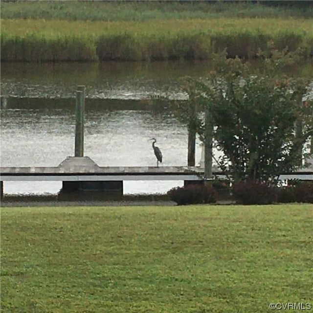 dock area featuring a lawn and a water view