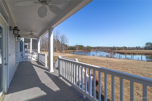 wooden deck with ceiling fan and a water view