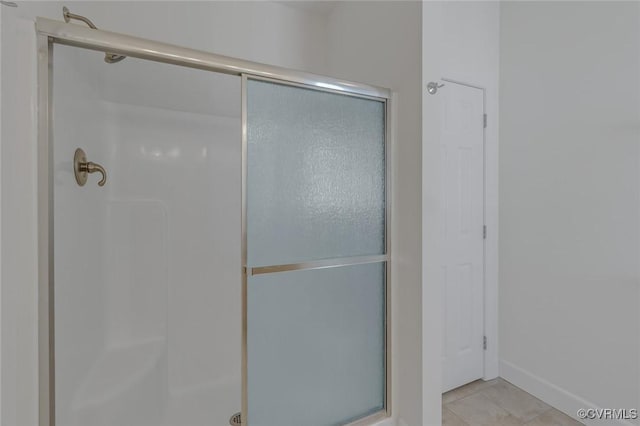 full bath with tile patterned flooring and a shower stall