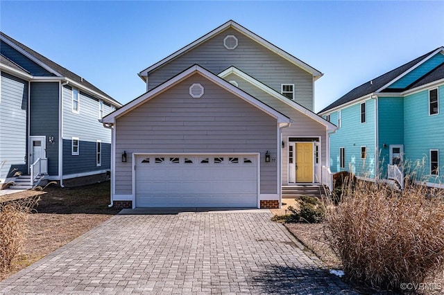 traditional-style house featuring an attached garage and decorative driveway