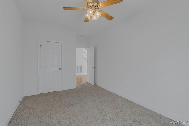 unfurnished bedroom featuring baseboards, a ceiling fan, and light colored carpet