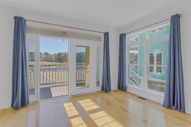 entryway with light wood finished floors, visible vents, and a wealth of natural light