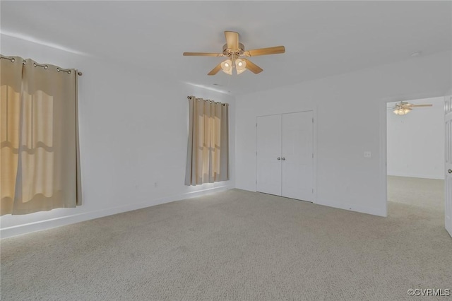 unfurnished bedroom featuring light carpet, ceiling fan, and a closet