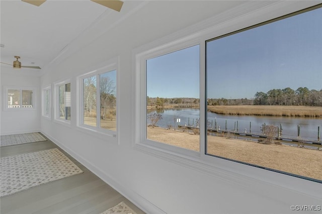 unfurnished sunroom featuring a water view and ceiling fan