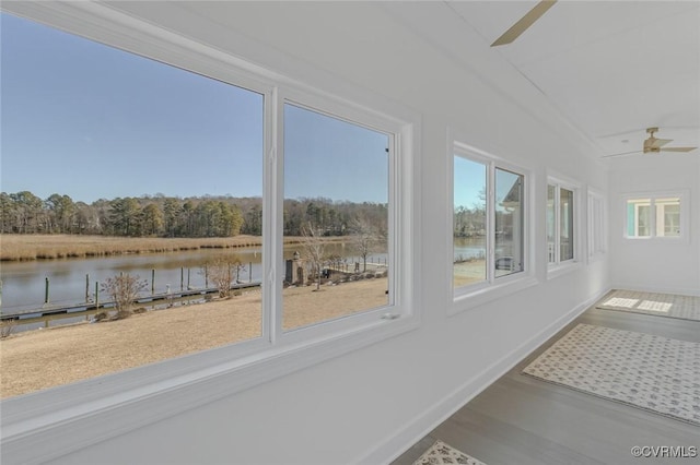 unfurnished sunroom with a water view and ceiling fan