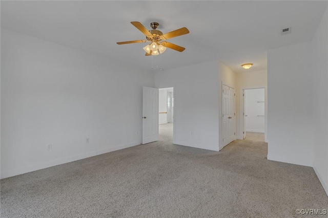 empty room with light colored carpet, visible vents, and a ceiling fan