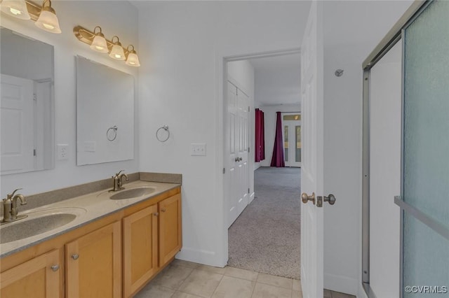 bathroom featuring double vanity, an enclosed shower, a sink, and tile patterned floors