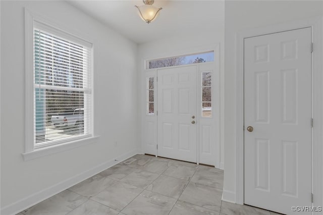 foyer entrance featuring marble finish floor and baseboards