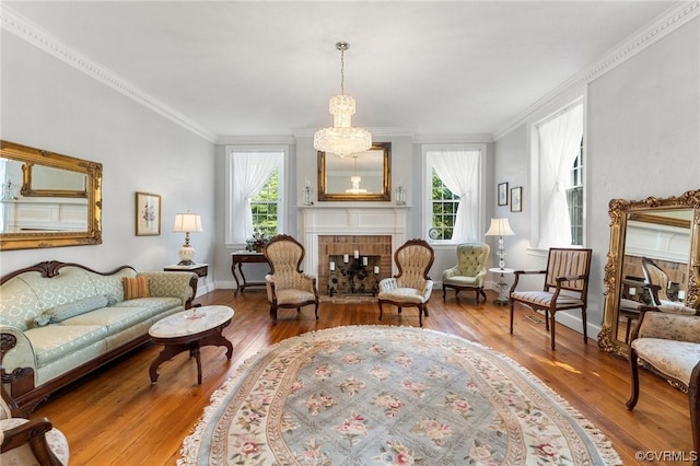 sitting room featuring a wealth of natural light, wood finished floors, a tile fireplace, and ornamental molding