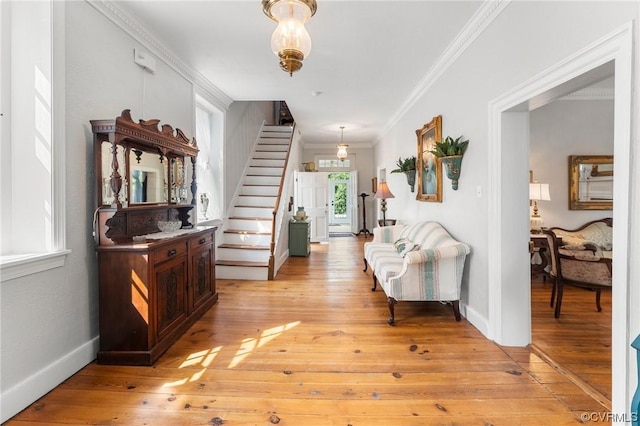 entrance foyer featuring baseboards, light wood-style flooring, stairs, and crown molding