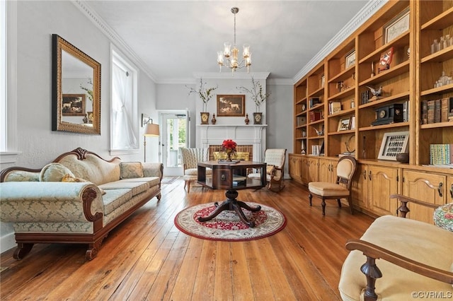 living area featuring a chandelier, built in features, ornamental molding, and wood-type flooring