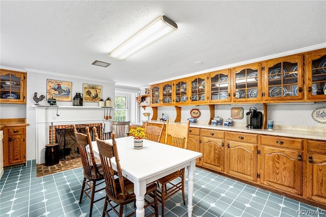 dining room with crown molding, light floors, and a textured ceiling