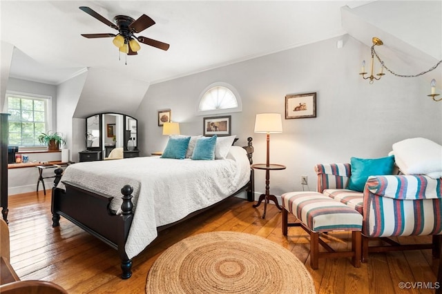 bedroom featuring vaulted ceiling, crown molding, a ceiling fan, and hardwood / wood-style flooring