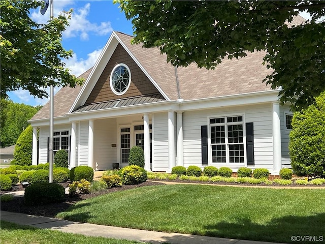 view of front of property with a front yard, a standing seam roof, and metal roof