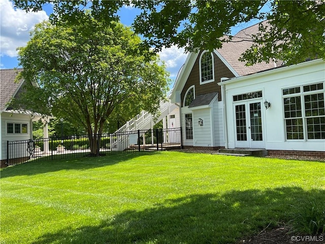 view of yard with french doors and fence