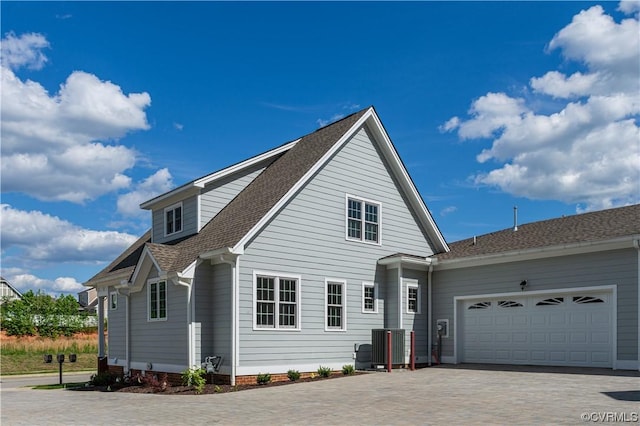 view of front of property featuring a garage, decorative driveway, and a shingled roof