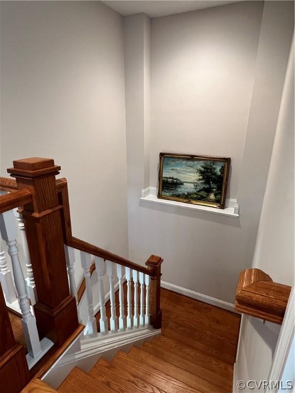 stairway featuring baseboards and wood finished floors