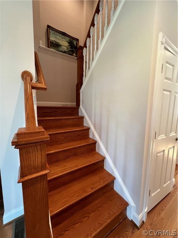 staircase featuring baseboards and wood finished floors