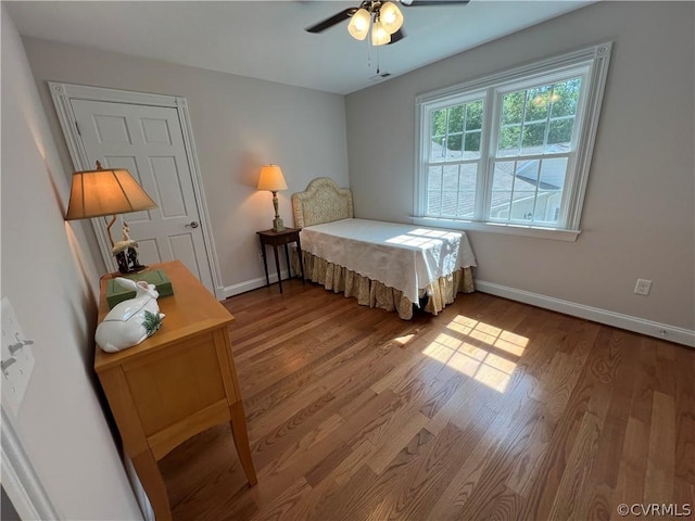 bedroom with visible vents, ceiling fan, baseboards, and wood finished floors