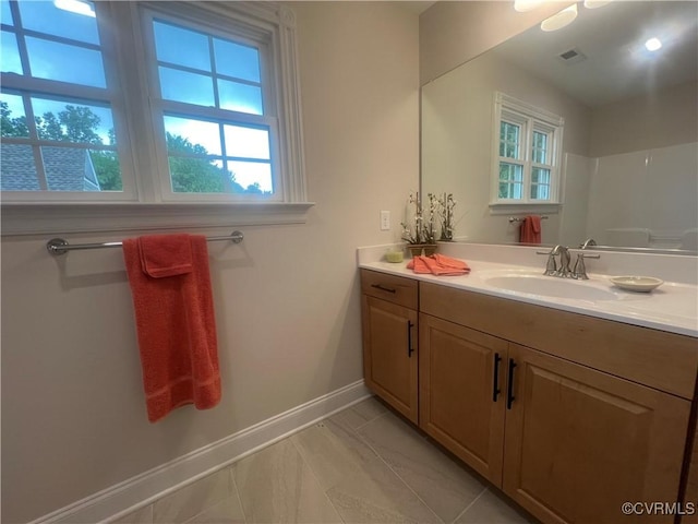 bathroom featuring visible vents, vanity, and baseboards