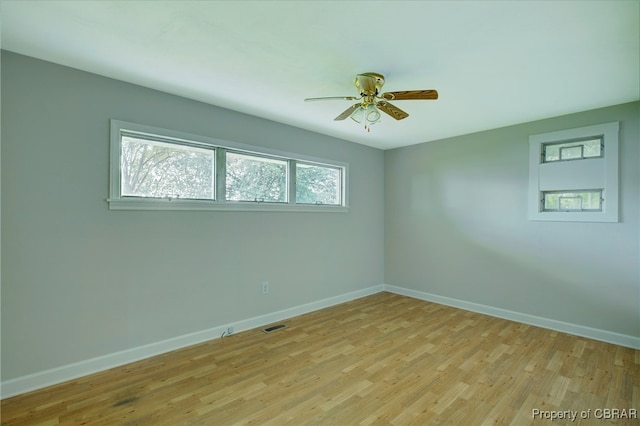 empty room with ceiling fan, light hardwood / wood-style floors, and a wealth of natural light