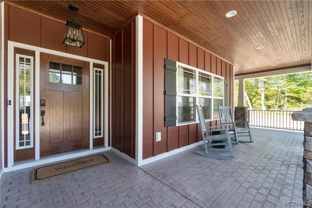 doorway to property featuring board and batten siding and covered porch