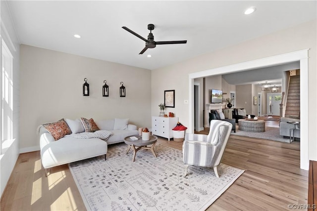 living area with stairs, recessed lighting, light wood finished floors, and ceiling fan