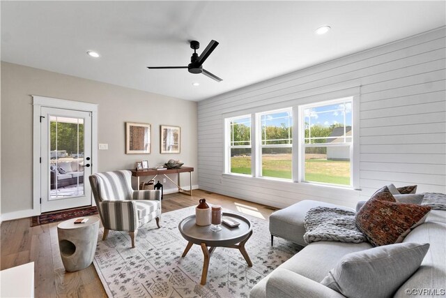 living room featuring ceiling fan, a wealth of natural light, and light hardwood / wood-style flooring