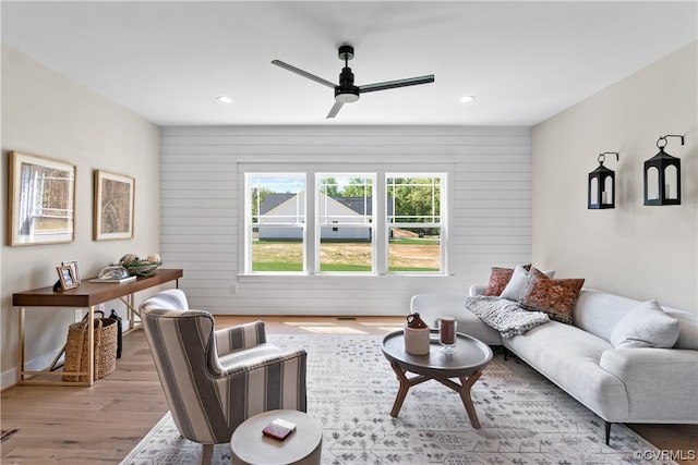 living room with light hardwood / wood-style flooring and ceiling fan