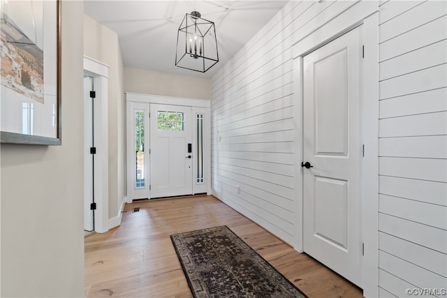 foyer entrance with light hardwood / wood-style floors and a chandelier