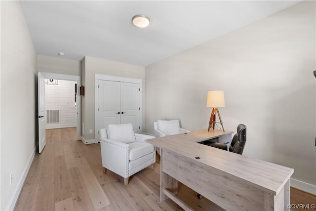 office space with visible vents, baseboards, and light wood-style floors