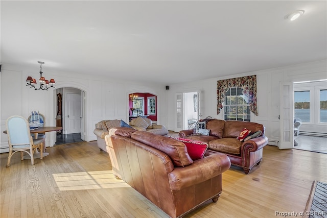 living room featuring a baseboard radiator, a notable chandelier, and light hardwood / wood-style floors