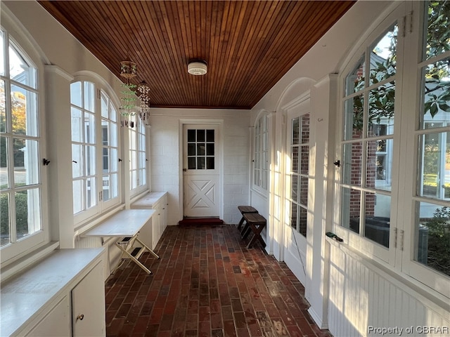 unfurnished sunroom with plenty of natural light and wooden ceiling